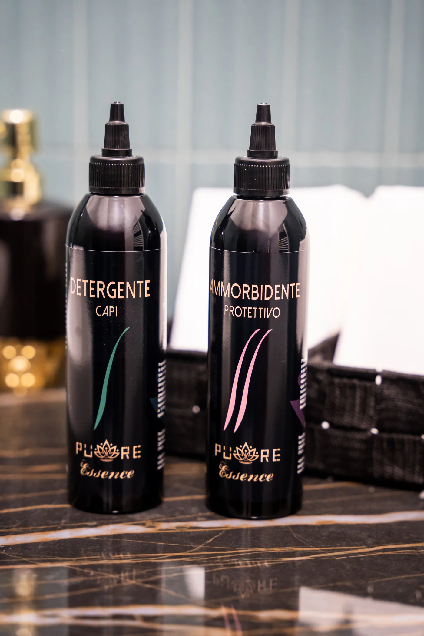 Detergente e Ammorbidente Pure Essence su tavolino con logo a loto dorato